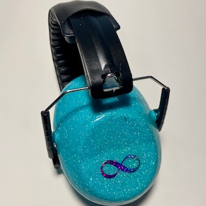 May include: Turquoise blue earmuffs with a black headband and an infinity symbol design. The earmuffs are covered in glitter.