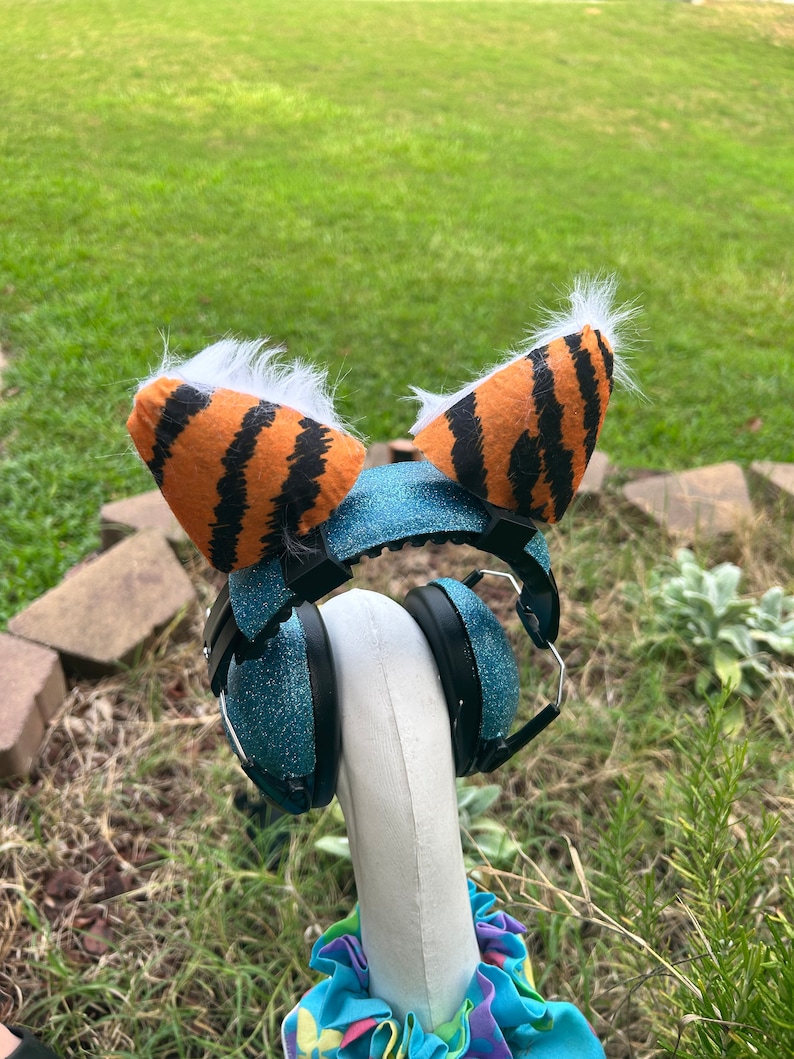 May include: Blue headphones with a sparkly finish and tiger-striped earmuffs with white fur trim.
