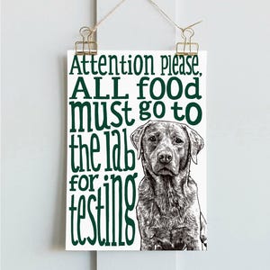 May include: A green and white sign with a black and white illustration of a Labrador Retriever. The sign reads "Attention please, ALL food must go to the lab for testing."