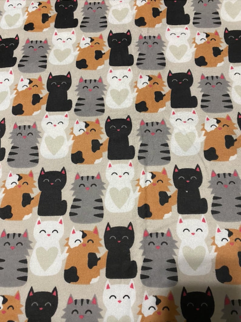 May include: A beige fabric with a repeating pattern of black, white, grey, and orange cats. The cats are all in different poses, some are sitting, some are standing, and some are lying down. The cats are all smiling and have hearts on their chests.
