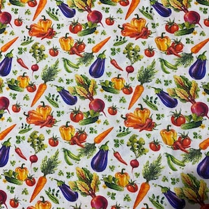 Op de afbeelding: Een witte stof met een herhalend patroon van kleurrijke groenten, waaronder oranje wortels, paarse aubergines, rode tomaten, gele en oranje paprika's, groene komkommers, rode radijsjes, groene erwten en groene kruiden.