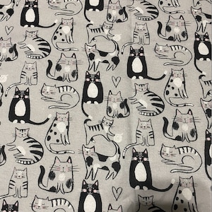 May include: A grey and white fabric with a repeating pattern of black and white cats in various poses. The cats have different markings and some have hearts on their chests.