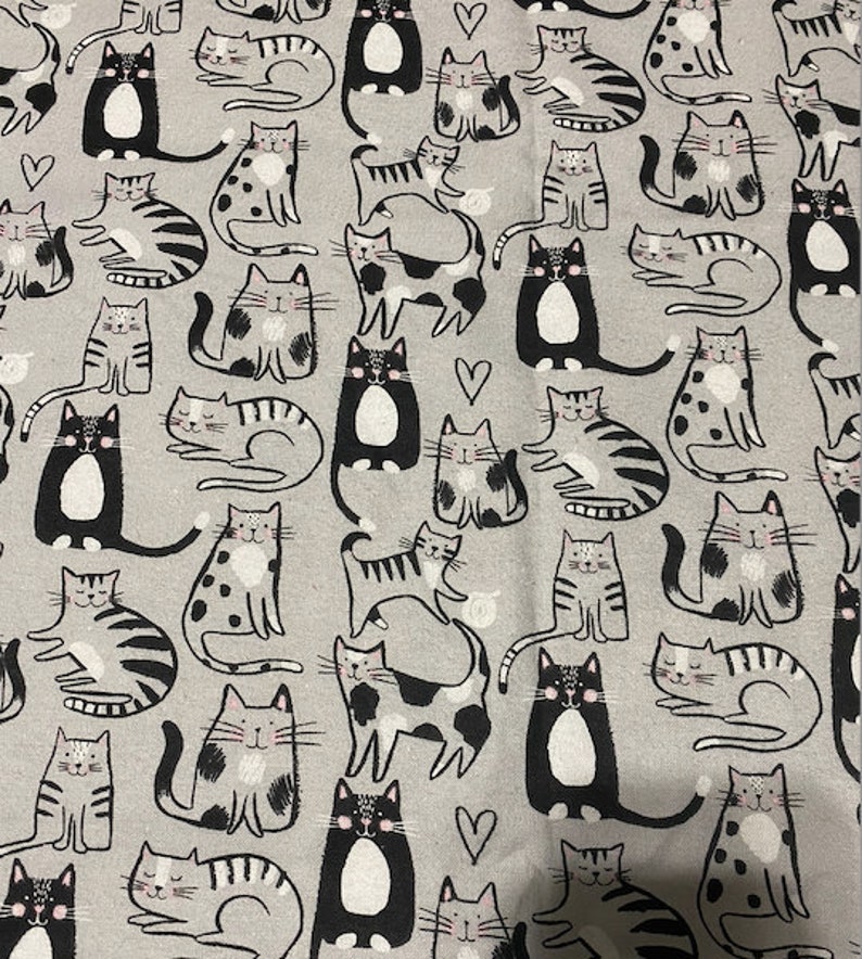 May include: A grey and white fabric with a repeating pattern of black and white cats in various poses. The cats have different markings and some have hearts on their chests.