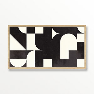 May include: Abstract geometric art print featuring a black and off-white design. The artwork is composed of various shapes, including squares, semi-circles, and triangles, set against a textured background. The print is framed in a natural wood frame.