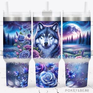 Puede incluir: Un vaso de acero inoxidable con asa blanca y un diseño colorido que presenta un lobo, flores y una luna. El diseño está en tonos azules, morados y rosas.