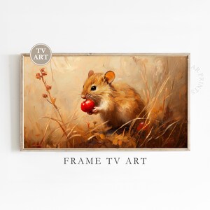 Może przedstawiać: Oprawiony wydruk przedstawiający szczegółowy obraz brązowej myszy trzymającej czerwoną jagodę. Grafika ma ciepłą paletę barw z odcieniami beżu, brązu i czerwieni, a u dołu widoczny jest napis "FRAME TV ART".