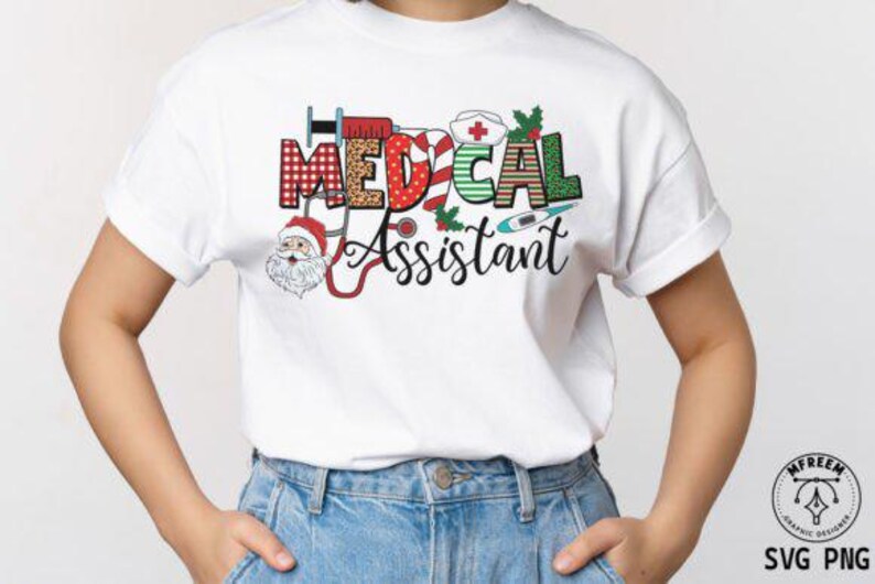 May include: White t-shirt featuring the words "MEDICAL ASSISTANT" in a festive, colourful design. The design incorporates medical symbols and a Santa Claus figure. The shirt is worn with blue jeans.