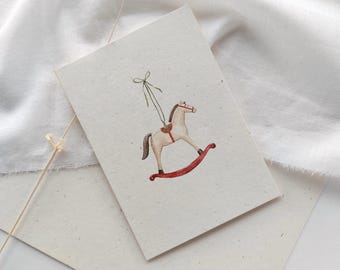 Carte de Noël sur papier paille | Carte de Noël avec cheval à bascule aquarelle | Courrier de Noël | Carte postale | Carte pliée | Carte de vœux écoresponsable