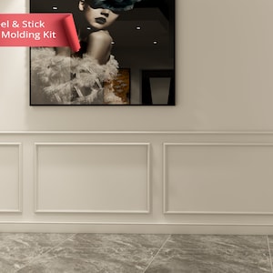 May include: White peel and stick wall moulding kit with a decorative trim around the edges. The moulding is installed on a white wall with a grey tiled floor. The text "Peel & Stick Wall Moulding Kit" is displayed in red on a white background.