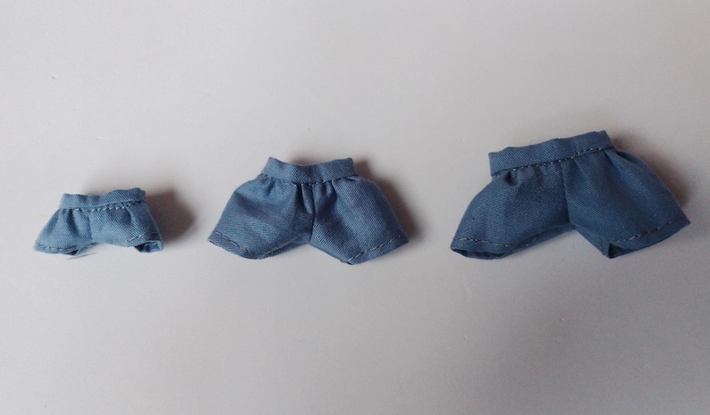 May include: Three pairs of blue denim shorts in different sizes. The shorts are made of a soft, lightweight fabric and have a casual, relaxed fit.