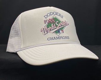 Könnte beinhalten: Weiße Trucker-Kappe mit einem blauen, roten und grünen Logo, auf dem "Dodgers 1988 World Series Champions" steht.