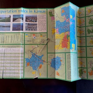 May include: A folded map of Kansas with a mileage map, a map of the state, and a map of the Kansas City metropolitan area. The map shows transportation modes in Kansas, including highways, railroads, and airports. The map also includes information about the population of cities and towns in Kansas.