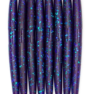 May include: A pack of eight purple and teal glitter fishing lures. The lures are long and slender with a pointed end.