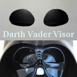 May include: A close-up of a black Darth Vader helmet with the text "Darth Vader Visor" in white. The image shows the visor and the top of the helmet.