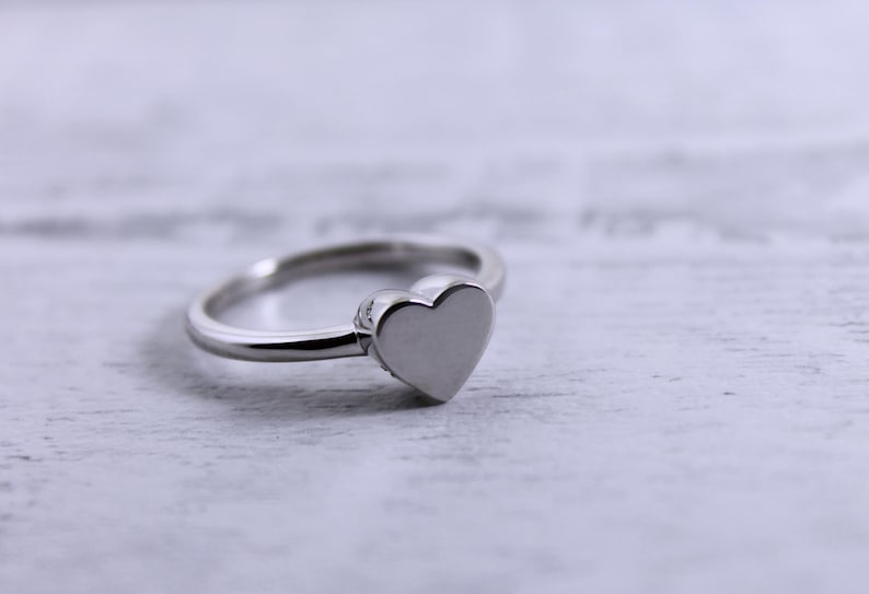 May include: A silver ring with a heart-shaped design.