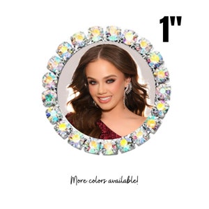 May include: A 1-inch round photo frame with a clear, iridescent rhinestone border. The frame is designed to hold a photo of a person. More colours are available.