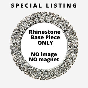May include: A circular rhinestone base piece, with a ring of clear, sparkling rhinestones. The center of the piece is white with the text "Rhinestone Base Piece ONLY" and "NO image NO magnet" in black.