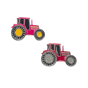 Puede incluir: Dos tractores de juguete rojos con detalles negros. Un tractor tiene ruedas amarillas y el otro tiene ruedas grises.