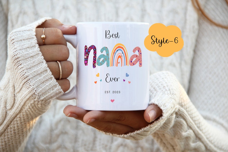 May include: White ceramic mug with a colorful rainbow and the text "Best Nana Ever Est. 2023" in black. The text "Style-6" is in a yellow speech bubble.