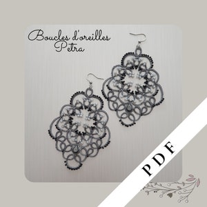 Peut inclure: Une paire de boucles d'oreilles argentées avec des perles noires et blanches, formant un motif floral délicat. Les boucles d'oreilles sont étiquetées "Boucles d'oreilles Petra" et "PDF".