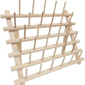 May include: A wooden thread spool holder with multiple dowels arranged in a grid pattern. The natural wood color of the holder provides a neutral backdrop for displaying spools of thread. The angled design allows for easy access to the spools.