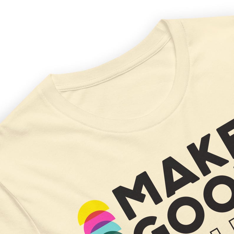 Pode incluir: Uma camiseta cor de creme com o texto "MAKE GOOD" em letras pretas. O "O" de "GOOD" &eacute; composto por semic&iacute;rculos coloridos.