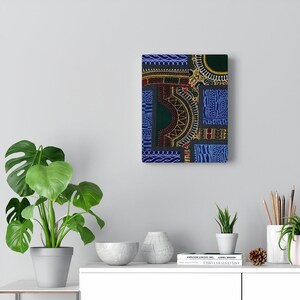May include: A framed abstract art print with a patchwork design of blue, green, red, and yellow geometric patterns. The print is framed in a black frame and is hanging on a white wall.