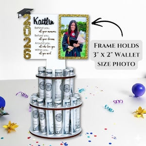 Graduation money holder 2026 photo frame option shown holding a 3x2 wallet-size photo. Personalized graduation money tree gift with rolled US dollar bill slots and Class of 2026 design. Graduation decorations Class of 2026 cash gift display.