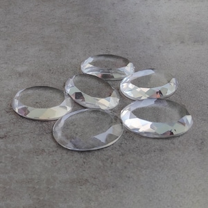 Peut inclure: Sept strass ovales en verre transparent avec un design facetté.