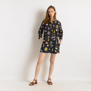 May include: A black button-down shirt dress with a colorful print of eyes, lips, and jewels. The dress has a relaxed fit and three-quarter sleeves.