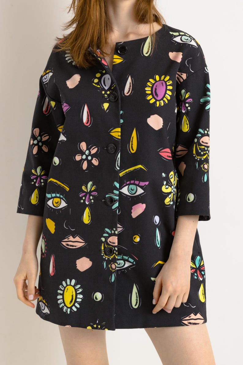 May include: A black button-up jacket with a colorful print of eyes, flowers, and teardrop shapes.