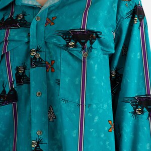 May include: A turquoise blue long-sleeved button-up shirt with a southwestern-inspired print featuring black, orange, and purple geometric designs.