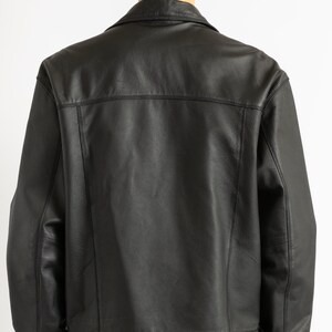 May include: A black leather jacket with a button-up front and a collar. The jacket has a classic denim jacket style.