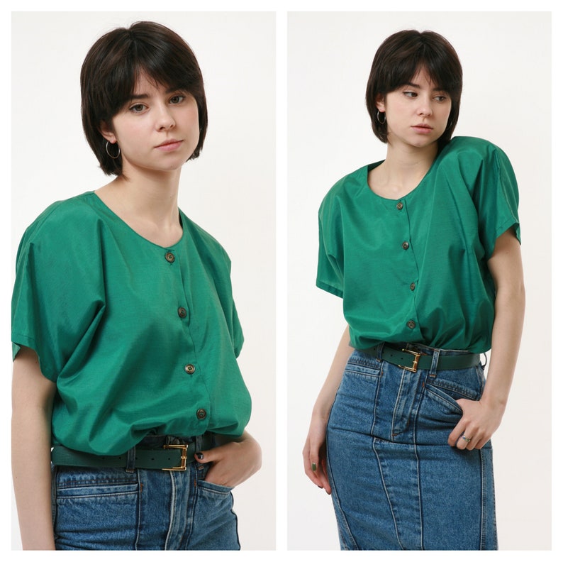 Puede incluir: Una camisa verde con botones, mangas cortas y cuello redondo. La camisa est&aacute; metida en un par de pantalones vaqueros azules con un cintur&oacute;n marr&oacute;n.