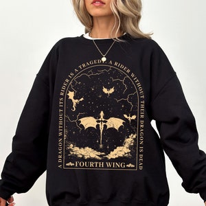 Pode incluir: Camisola de moletom preta com um gr&aacute;fico dourado de um drag&atilde;o e o texto "A dragon without its rider is a tragedy. A rider without their dragon is dead. Fourth Wing."