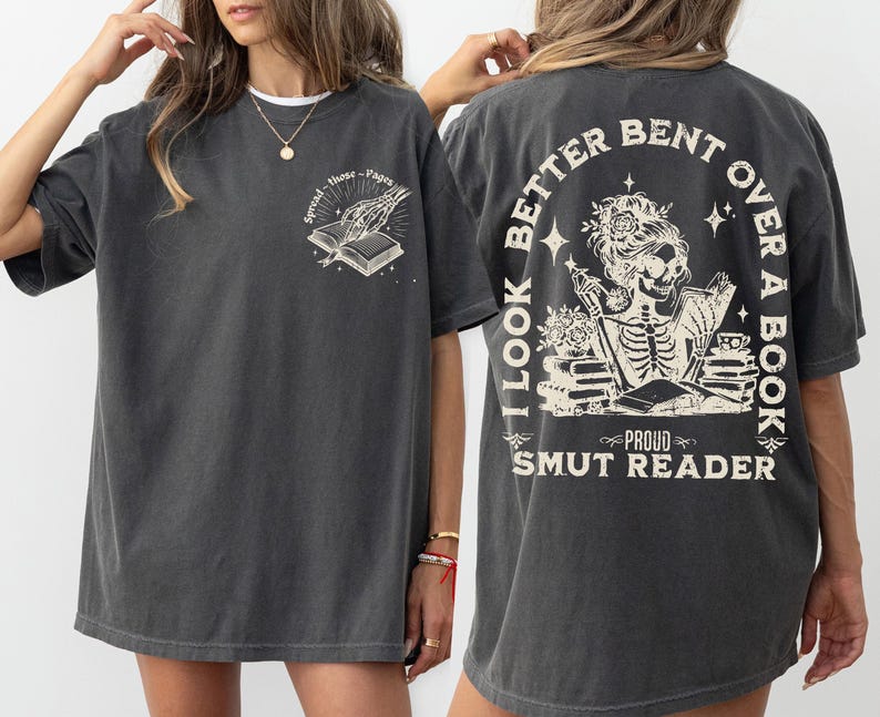 May include: A dark gray oversized t-shirt with a skeleton reading a book graphic and the text "I look better bent over a book, Proud Smut Reader".