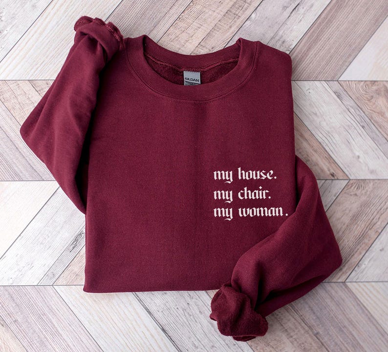 May include: Burgundy sweatshirt with the text "my house. my chair. my woman." in white.