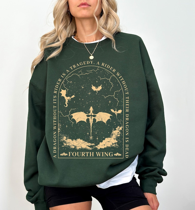 Pode incluir: Uma camisa de moletom verde escura com uma estampa gr&aacute;fica de um drag&atilde;o e o texto "A dragon without its rider is a tragedy, a rider without their dragon is dead. Fourth Wing."