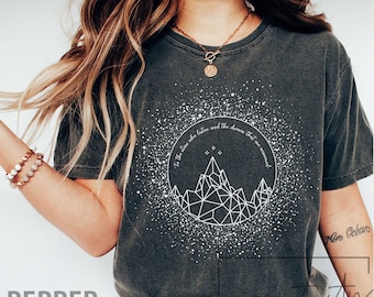 May include: A dark gray t-shirt with a white graphic design of a mountain range with stars and the text "To the stars who listen and the dreams that are answered".