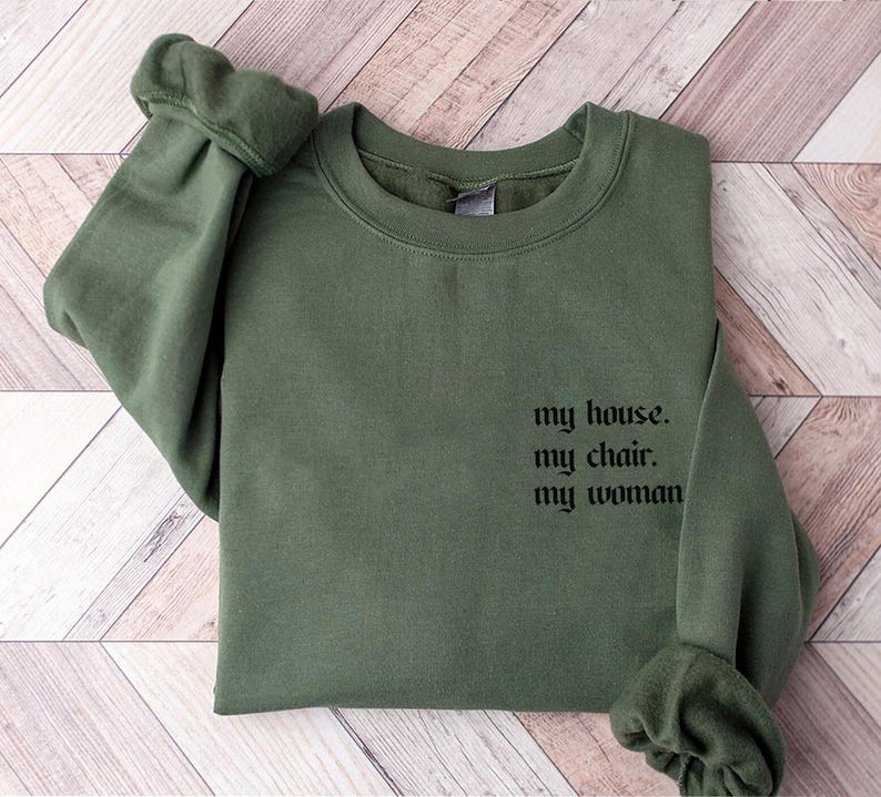 May include: A green sweatshirt with the text "my house. my chair. my woman" printed on the front.