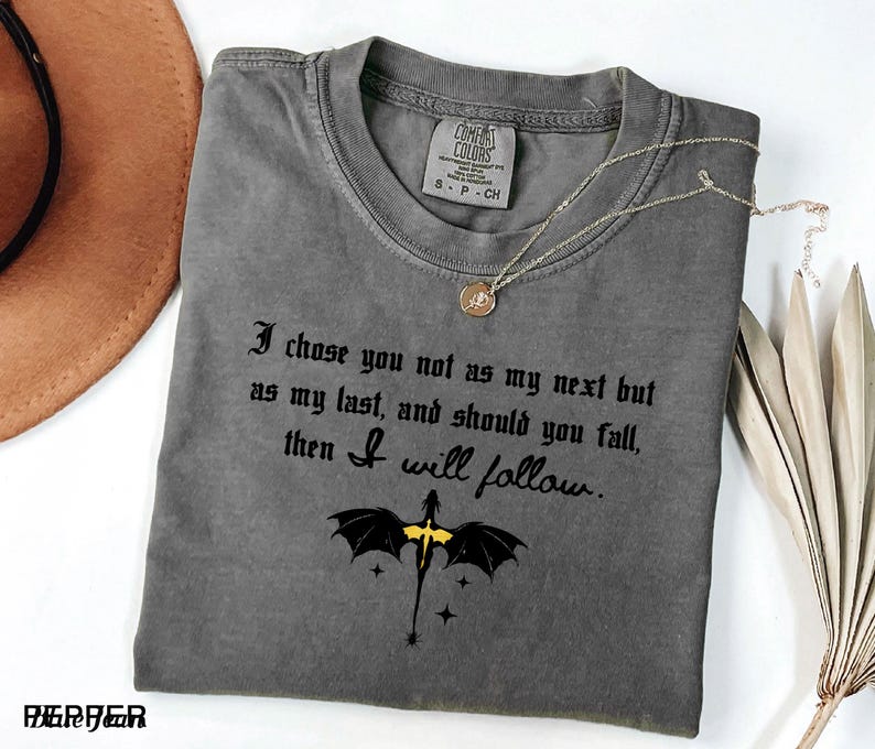 May include: A gray Comfort Colors t-shirt with the text "I chose you not as my next but as my last, and should you fall, then I will follow." A dragon graphic is below the text. A gold necklace is on the shirt.