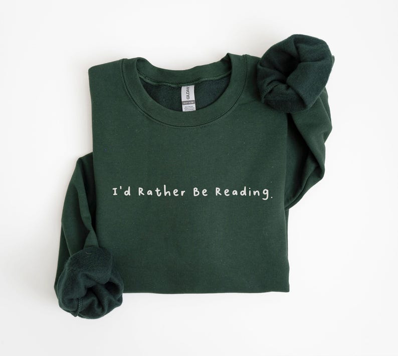 K&ouml;nnte beinhalten: Ein dunkelgr&uuml;ner Pullover mit dem Text "I'd Rather Be Reading." in Wei&szlig;.