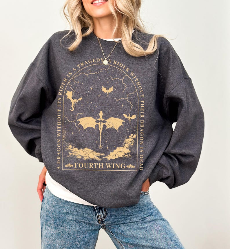 Pode incluir: Uma camisa de moletom cinza escura com uma estampa gr&aacute;fica de um drag&atilde;o e o texto "A dragon without its rider is a tragedy. A rider without their dragon is dead. Fourth Wing."