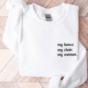 May include: White sweatshirt with the text "my house. my chair. my woman." printed in black.