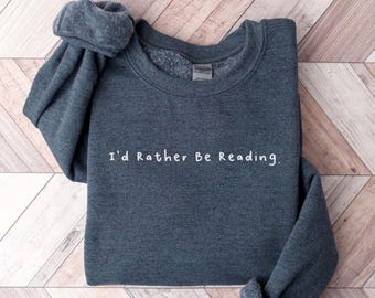 May include: A dark gray sweatshirt with the text "I'd Rather Be Reading." printed in white on the front.