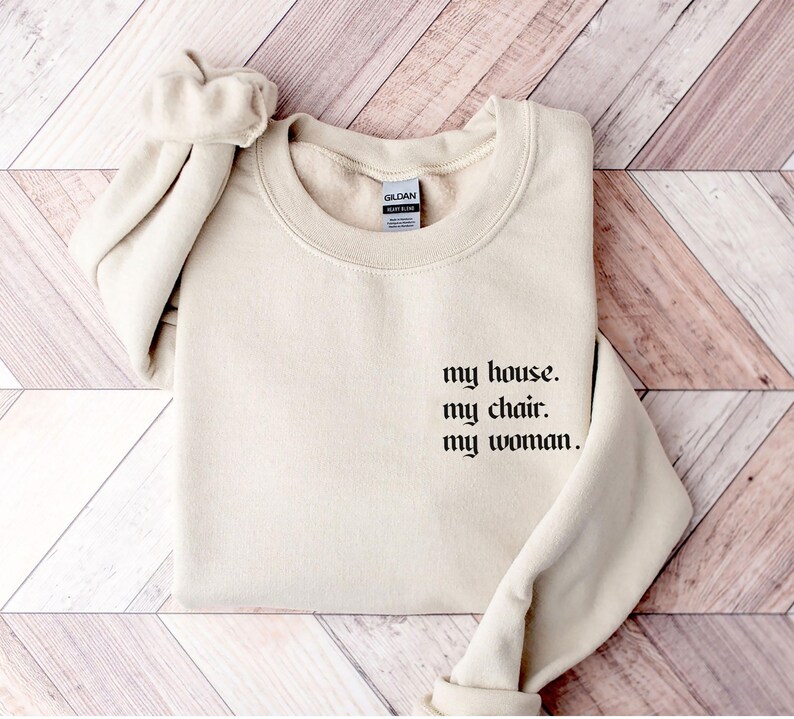 May include: A cream-colored sweatshirt with the text "my house. my chair. my woman." printed in black.