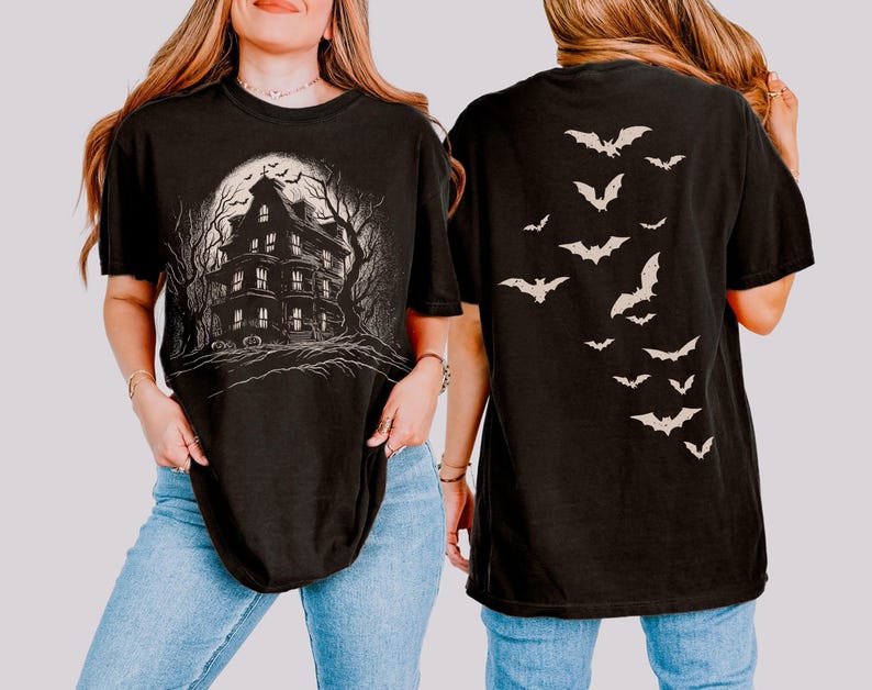 May include: Black t-shirt with a haunted house graphic on the front and a bat design on the back. The front graphic shows a spooky house under a full moon. The back of the shirt has a descending pattern of bats.