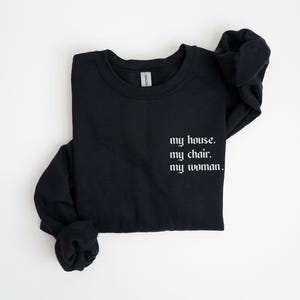 May include: Black sweatshirt with the text "my house. my chair. my woman." printed in white.