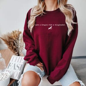 May include: A maroon sweatshirt with the text "save a dragon ride a wingleader." printed in white on the front.
