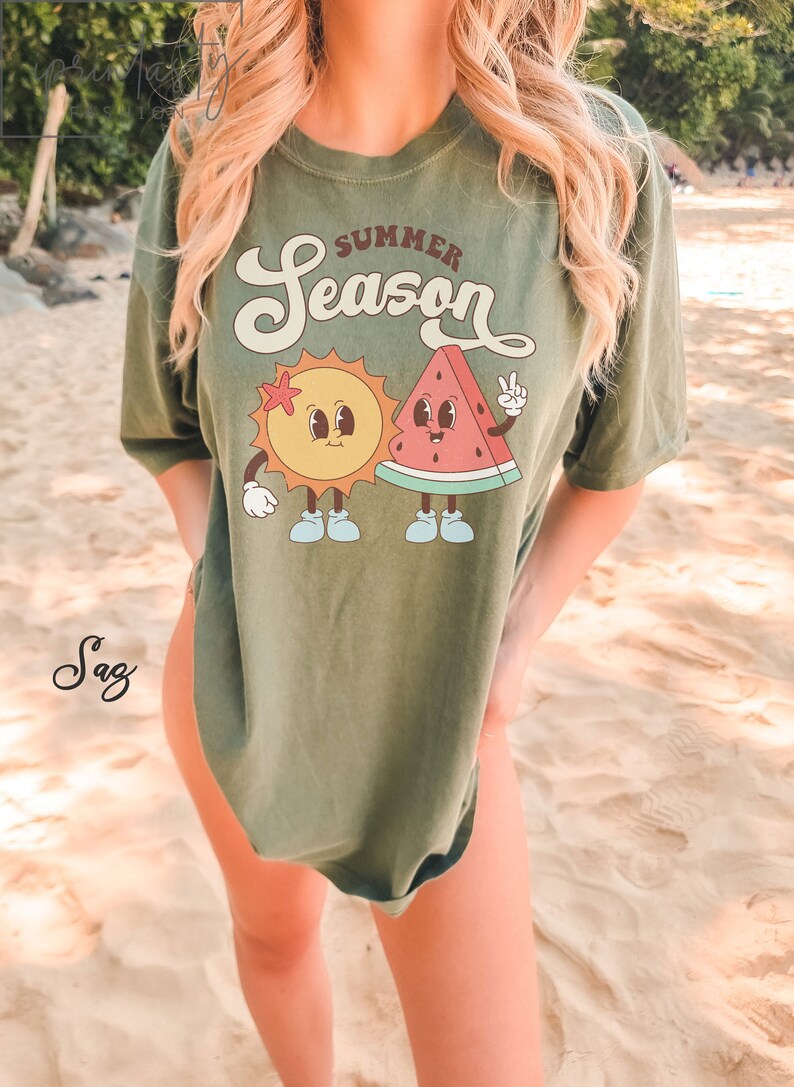 May include: A green t-shirt with the text "Summer Season" in a retro font. The shirt features a cartoon sun and watermelon with smiling faces.